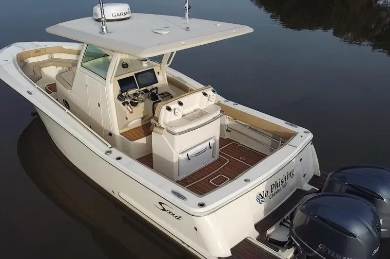 Slide: The Image of 2016 Scout 300 LXF boat with dual engines on calm water. - 10