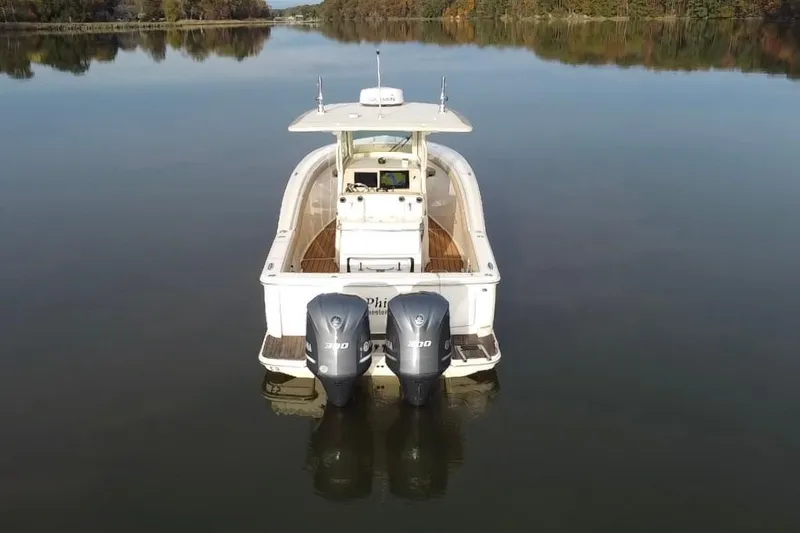 Slide: The Image of 2016 Scout 300 LXF boat with twin Yamaha 300 engines on a calm lake. - 11
