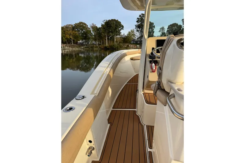 Slide: The Image of 2016 Scout 300 LXF boat dashboard with control panel and water view. - 16