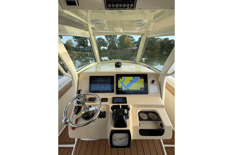 Slide: The Image of 2016 Scout 300 LXF boat interior with beige seating on calm water. - 20