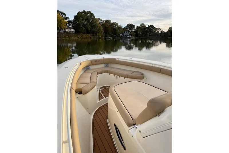 Slide: The Image of 2016 Scout 300 LXF boat interior with beige seating and wooden deck. - 21