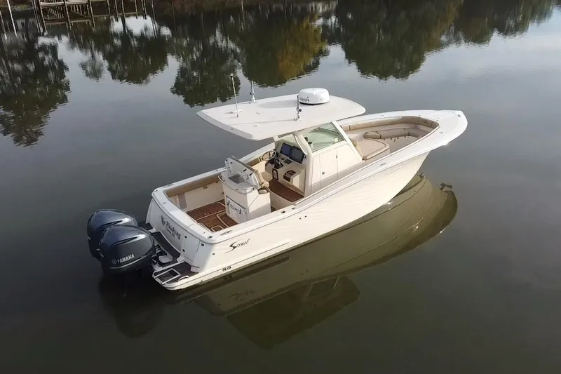 Slide: The Image of 2016 Scout 300 LXF boat on calm water, featuring dual engines and sleek design. - 4