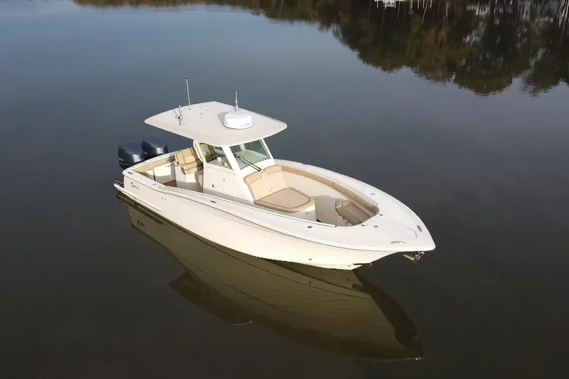 Slide: The Image of 2016 Scout 300 LXF boat on calm lake with wooded shoreline. - 5