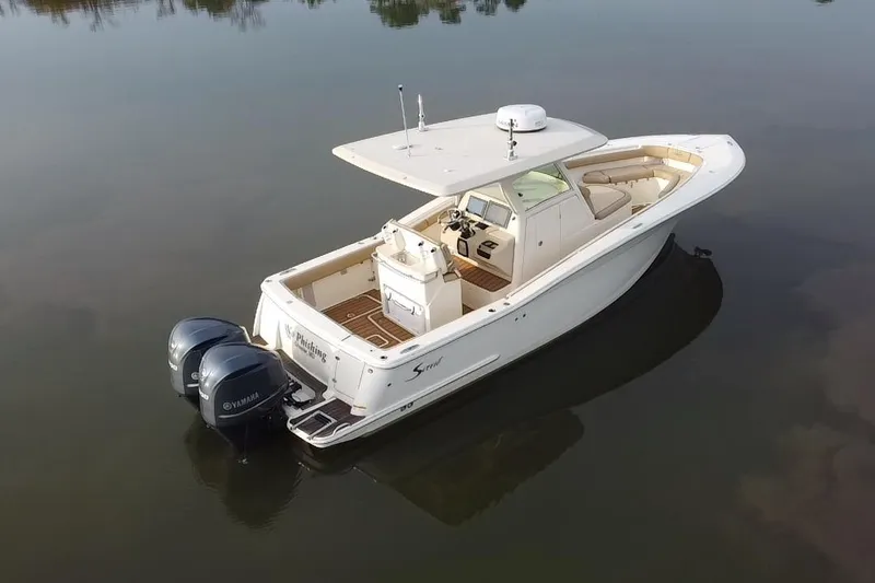 Slide: The Image of 2016 Scout 300 LXF boat with dual Yamaha engines on calm water. - 9