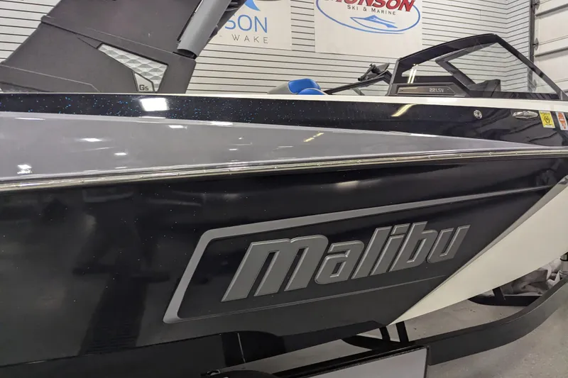 Slide: The Image of 2022 Malibu Wakesetter 22 LSV boat in showroom, sleek design and branding visible. - 11