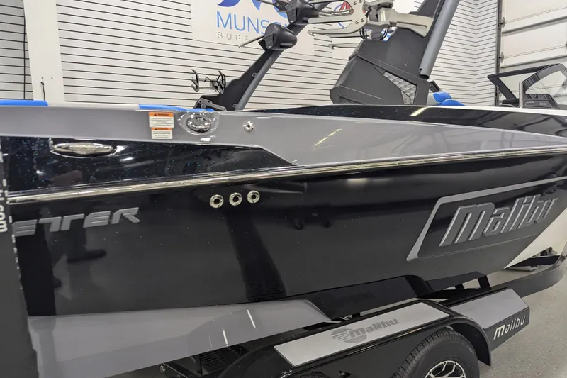 Slide: The Image of 2022 Malibu Wakesetter 22 LSV boat in showroom, sleek black and gray design. - 12