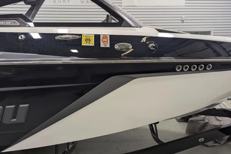 Slide: The Image of 2022 Malibu Wakesetter 22 LSV boat side view with sleek design and decals. - 13