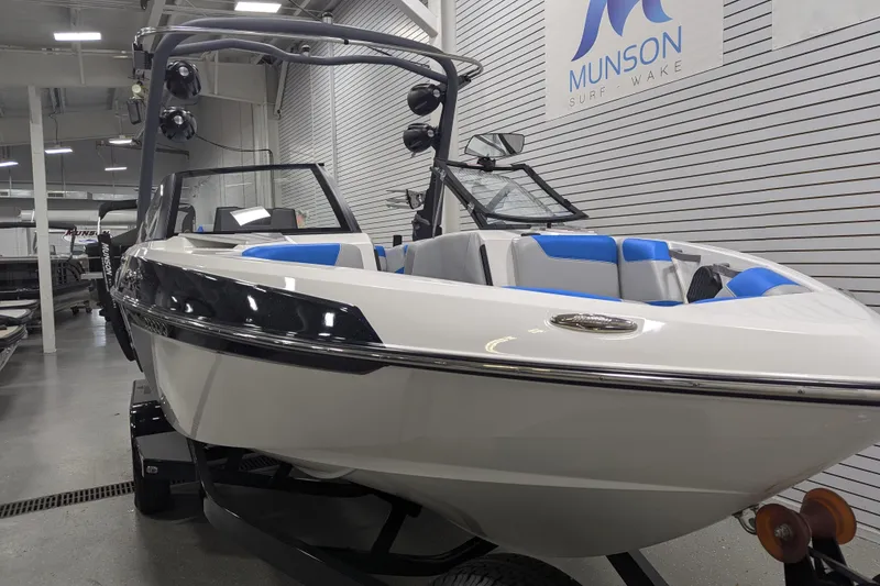 Slide: The Image of 2022 Malibu Wakesetter 22 LSV boat in showroom, featuring sleek design and blue accents. - 14