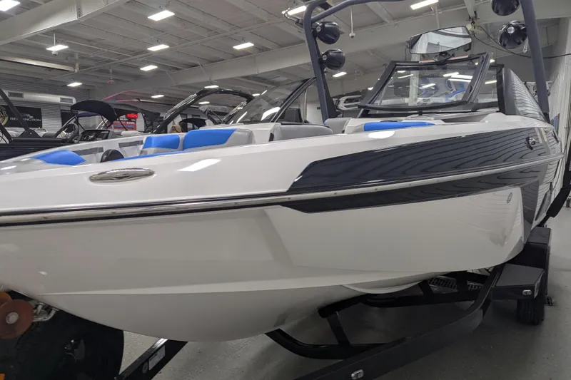 Slide: The Image of 2022 Malibu Wakesetter 22 LSV boat displayed indoors, featuring sleek design and blue seating. - 16
