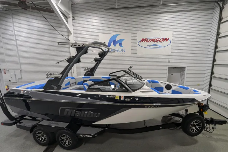 The Image of 2022 Malibu Wakesetter 22 LSV boat in showroom, black and white exterior, blue interior accents. - 9