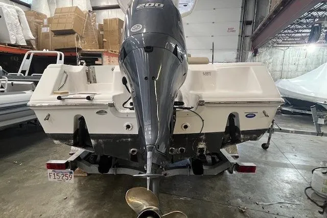 Slide: The Image of 2021 Tidewater 220 CC Adventure boat with powerful outboard motor in a storage facility. - 13