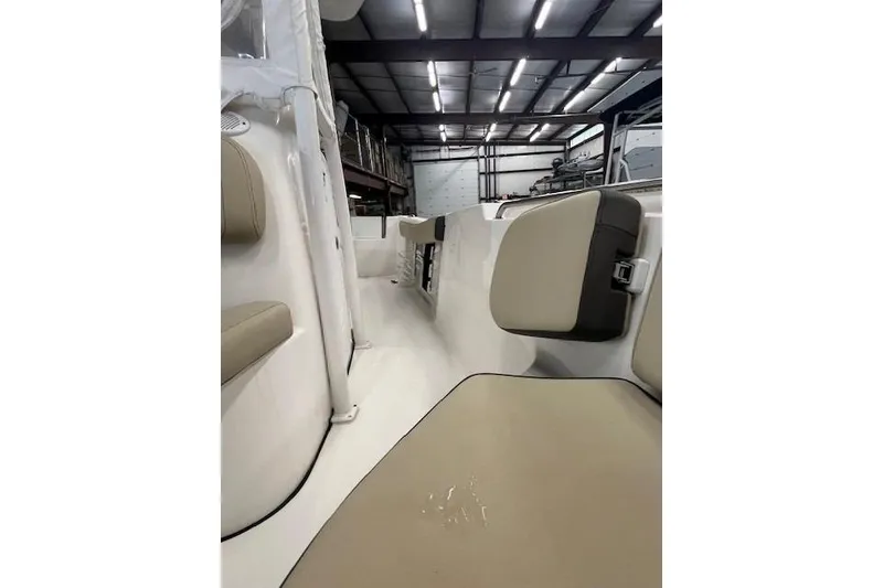 Slide: The Image of 2021 Tidewater 220 CC Adventure boat interior with beige seating in a warehouse. - 5