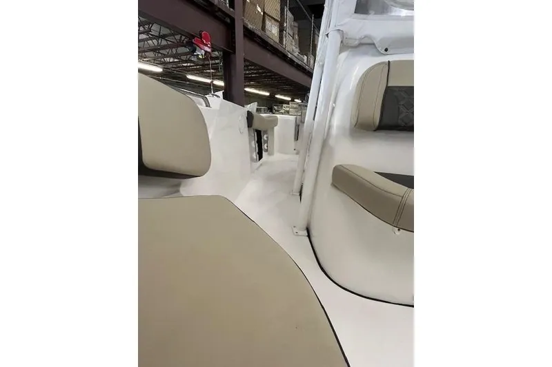 Slide: The Image of 2021 Tidewater 220 CC Adventure boat interior with beige seating and white deck. - 6