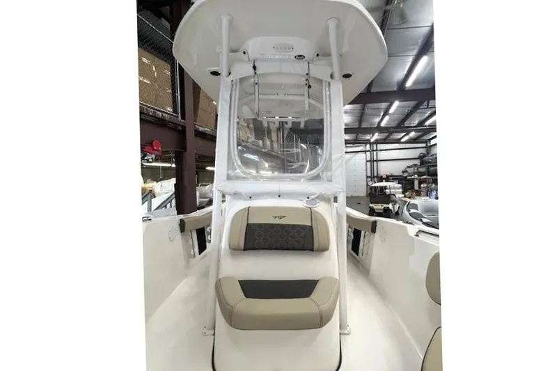 Slide: The Image of 2021 Tidewater 220 CC Adventure boat interior with seating and console in a warehouse. - 7