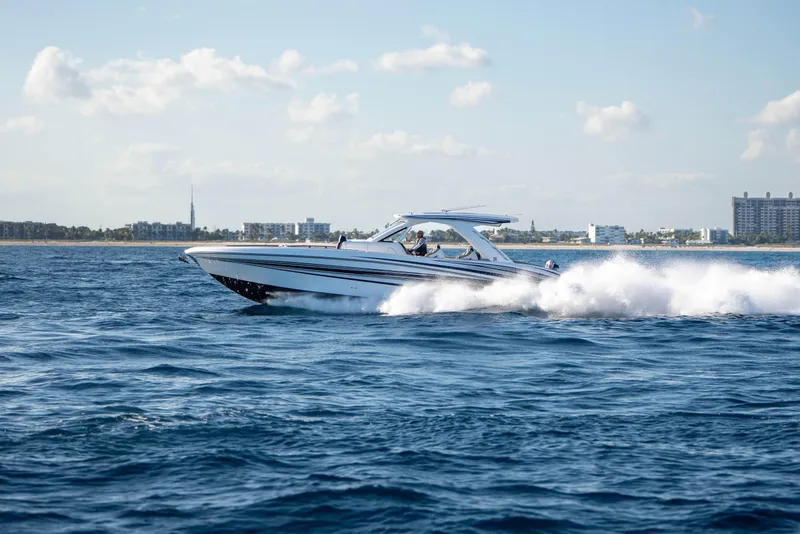 Slide: The Image of Sleek 2026 Deep Impact 449 Sport boat on calm ocean waters. - 49