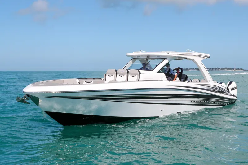 Slide: The Image of 2026 Deep Impact 449 Sport boat cruising on open water with city skyline in background. - 5