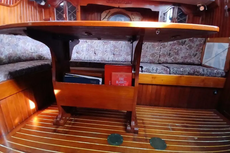 Slide: The Image of Interior of 1980 Hardin 45 sailboat with wooden table and floral seating. - 12