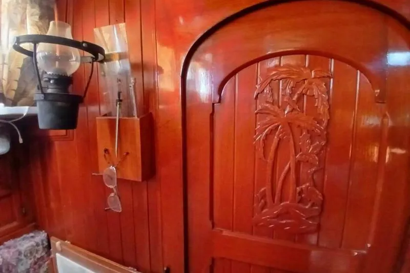 Slide: The Image of Wooden interior of 1980 Hardin 45 yacht with carved palm tree door and vintage lantern. - 13