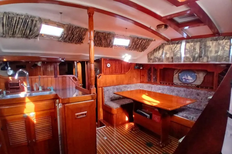 Slide: The Image of Interior of a 1980 Hardin 45 sailboat with wooden furnishings and cozy seating area. - 15
