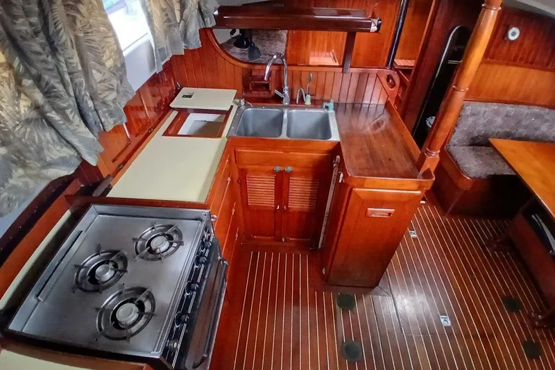 Slide: The Image of Interior of 1980 Hardin 45 sailboat kitchen with stove, sink, and wooden cabinetry. - 17