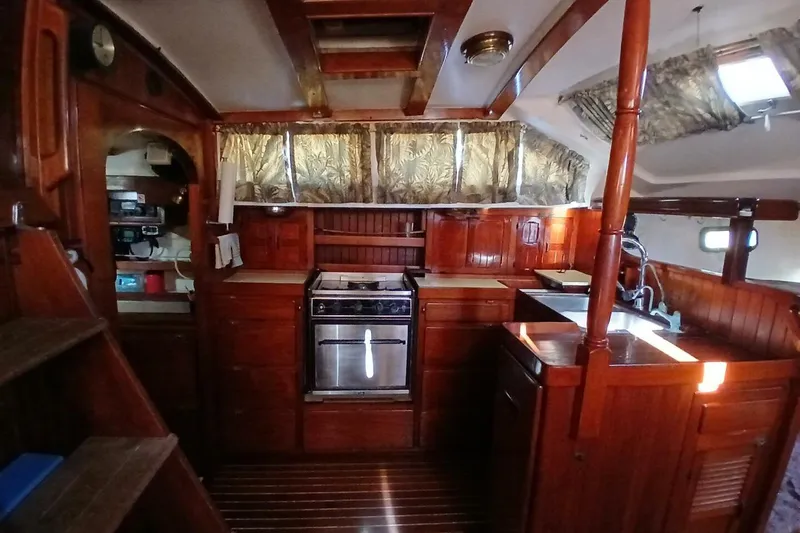 Slide: The Image of Interior of a 1980 Hardin 45 sailboat with wooden cabinetry and a compact kitchen. - 18