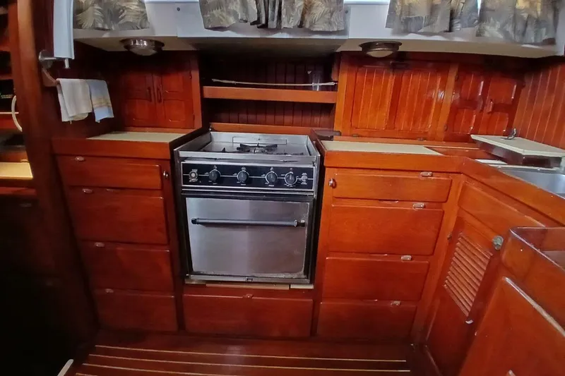 Slide: The Image of 1980 Hardin 45 yacht kitchen with wooden cabinetry and stainless steel stove. - 19