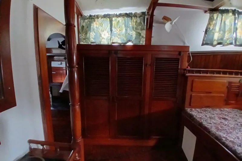Slide: The Image of Interior of a 1980 Hardin 45 sailboat with wooden cabinetry and floral curtains. - 31