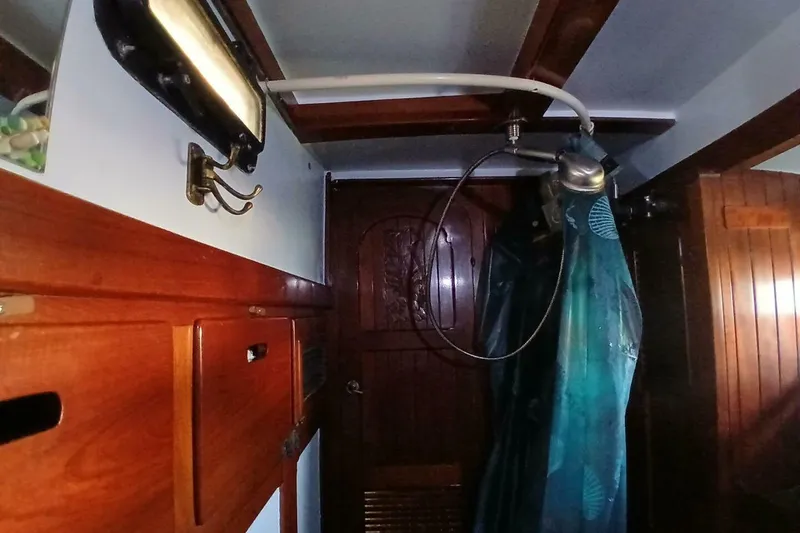 Slide: The Image of Interior of a 1980 Hardin 45 sailboat with wooden cabinetry and shower area. - 38