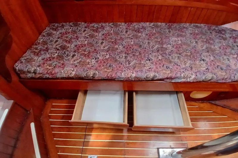 Slide: The Image of Wooden interior of 1980 Hardin 45 boat with floral cushion and open storage drawers. - 42