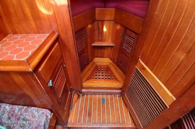 Slide: The Image of Interior of 1980 Hardin 45 sailboat with wooden paneling and red cushioned seating. - 53