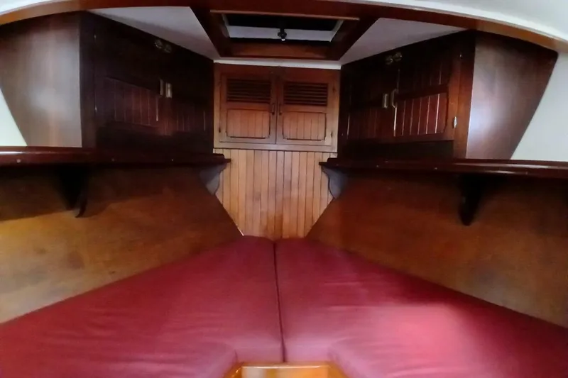 Slide: The Image of Interior cabin of 1980 Hardin 45 sailboat with wooden finish and red cushions. - 55