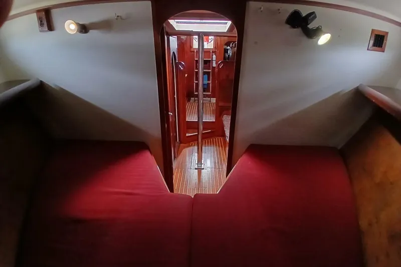 Slide: The Image of Interior of 1980 Hardin 45 sailboat with red cushions and wooden flooring. - 57