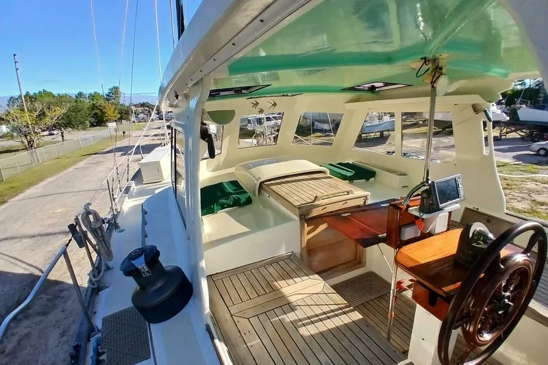 Slide: The Image of 1980 Hardin 45 sailboat cockpit with wooden deck, steering wheel, and navigation equipment. - 6