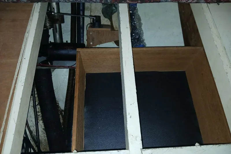 Slide: The Image of Wooden compartment in a 1980 Hardin 45 boat interior, showing pipes and mechanical components. - 71