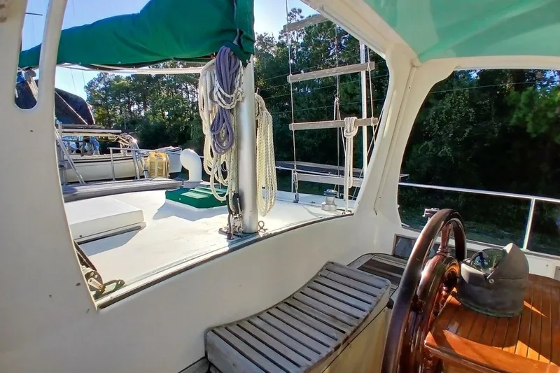 Slide: The Image of Interior view of a 1980 Hardin 45 sailboat, featuring a wooden steering wheel and deck. - 74