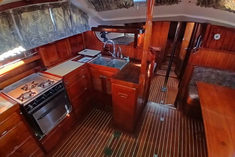 Slide: The Image of Interior of 1980 Hardin 45 sailboat with wooden cabinetry and kitchen amenities. - 9