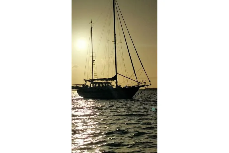 Slide: The Image of Sailing yacht Hardin 45 silhouetted against sunset, 1980 model on tranquil waters. - 91