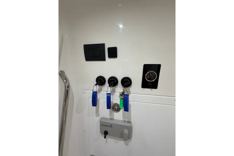 Slide: The Image of Control panel of 2025 Deep Impact 369 Sport boat with keys and Garmin device. - 11