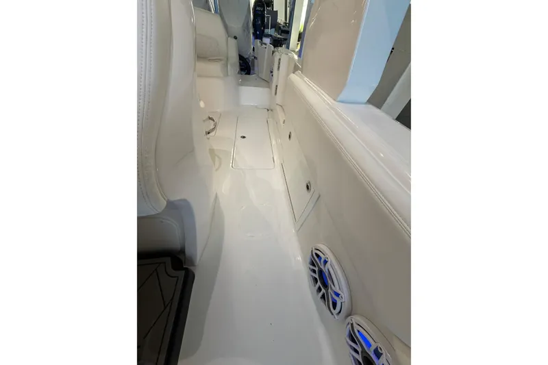 Slide: The Image of Interior view of 2025 Deep Impact 369 Sport boat, featuring sleek white seating and blue-lit speakers. - 17