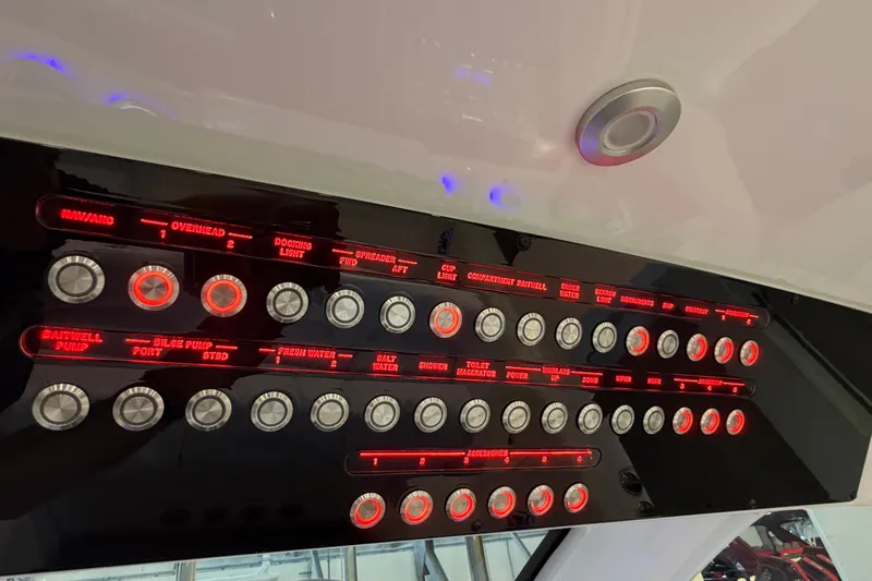 Slide: The Image of Control panel of 2025 Deep Impact 369 Sport boat with illuminated switches and labels. - 23