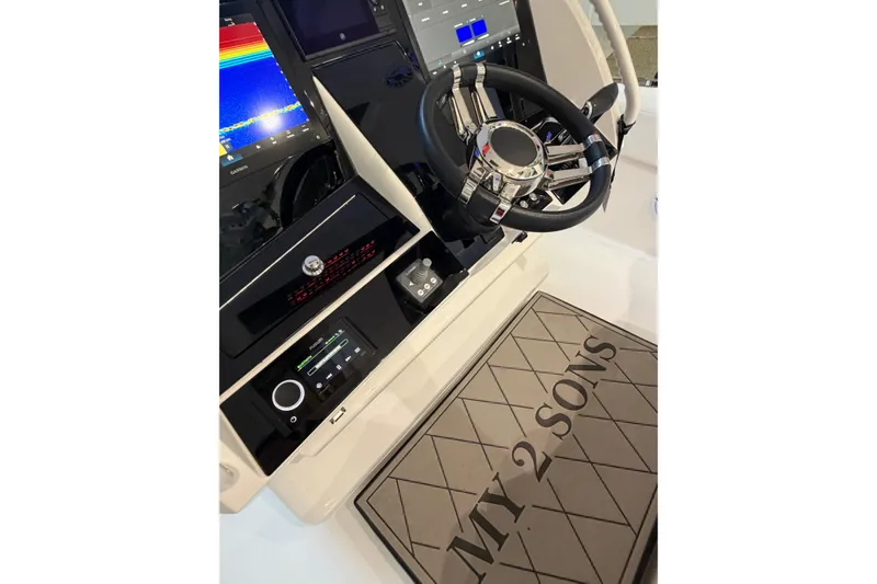Slide: The Image of 2025 Deep Impact 369 Sport boat dashboard with steering wheel and "MY 2 SONS" mat. - 24