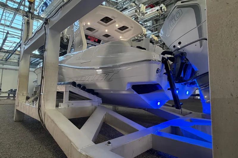 Slide: The Image of 2025 Deep Impact 369 Sport boat on lift, illuminated with blue lights in a marina. - 33