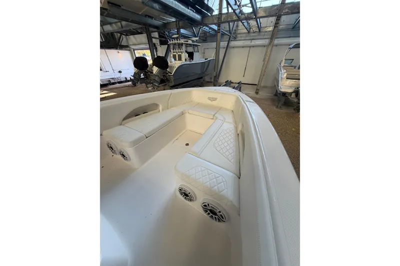 Slide: The Image of 2025 Deep Impact 369 Sport boat interior with white seating and speakers in a showroom. - 5