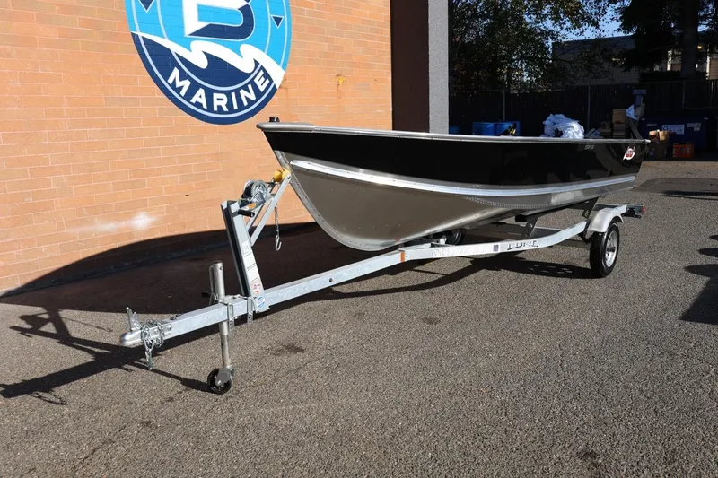 Slide: The Image of 2026 Lund SSV-16 Tiller boat on trailer, parked outside B Marine building. - 13