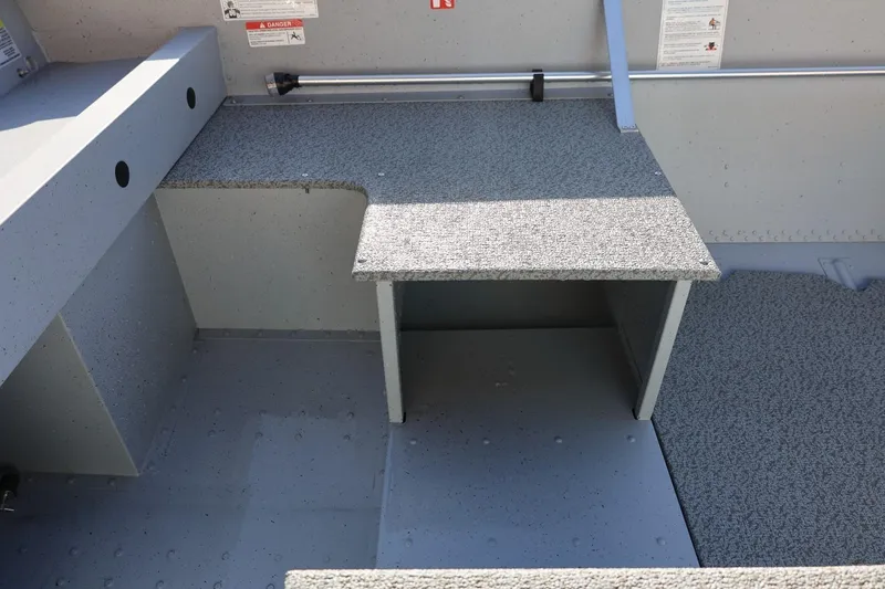 Slide: The Image of 2026 Lund SSV-16 Tiller boat interior with textured flooring and storage compartment. - 16