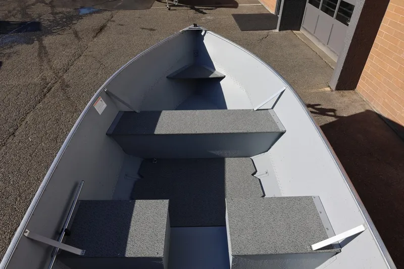 Slide: The Image of 2026 Lund SSV-16 Tiller boat interior with gray seating and flooring. - 19