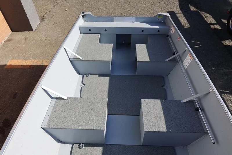 Slide: The Image of 2026 Lund SSV-16 Tiller boat interior with gray seating and storage compartments. - 21