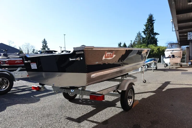 Slide: The Image of 2026 Lund SSV-16 Tiller boat on trailer, parked outdoors in a dealership lot. - 8