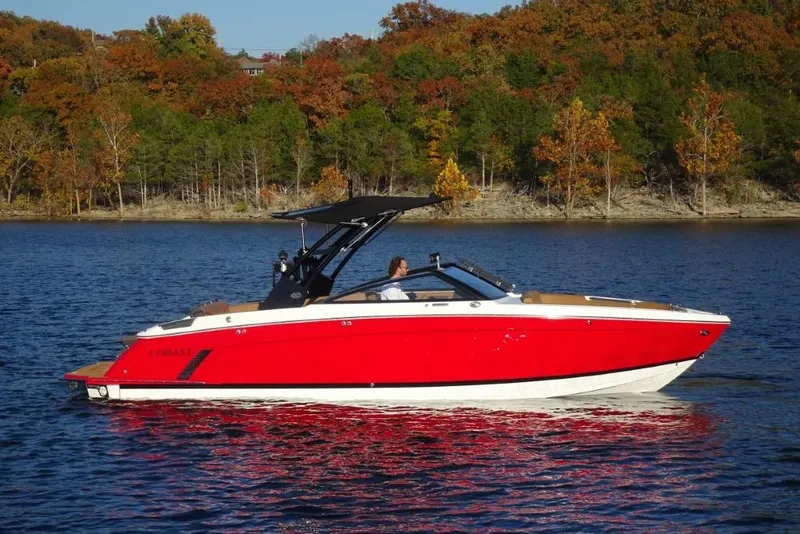 Slide: The Image of 2026 Cobalt R8 Surf boat on a lake with autumn trees in the background. - 2
