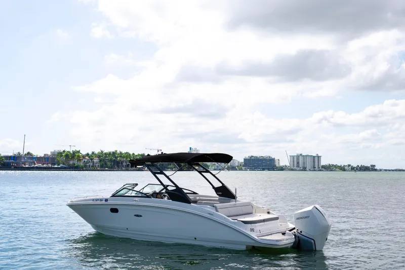 The Image of 2021 Yamaha Boats AR250 on calm water with cityscape background. - 0